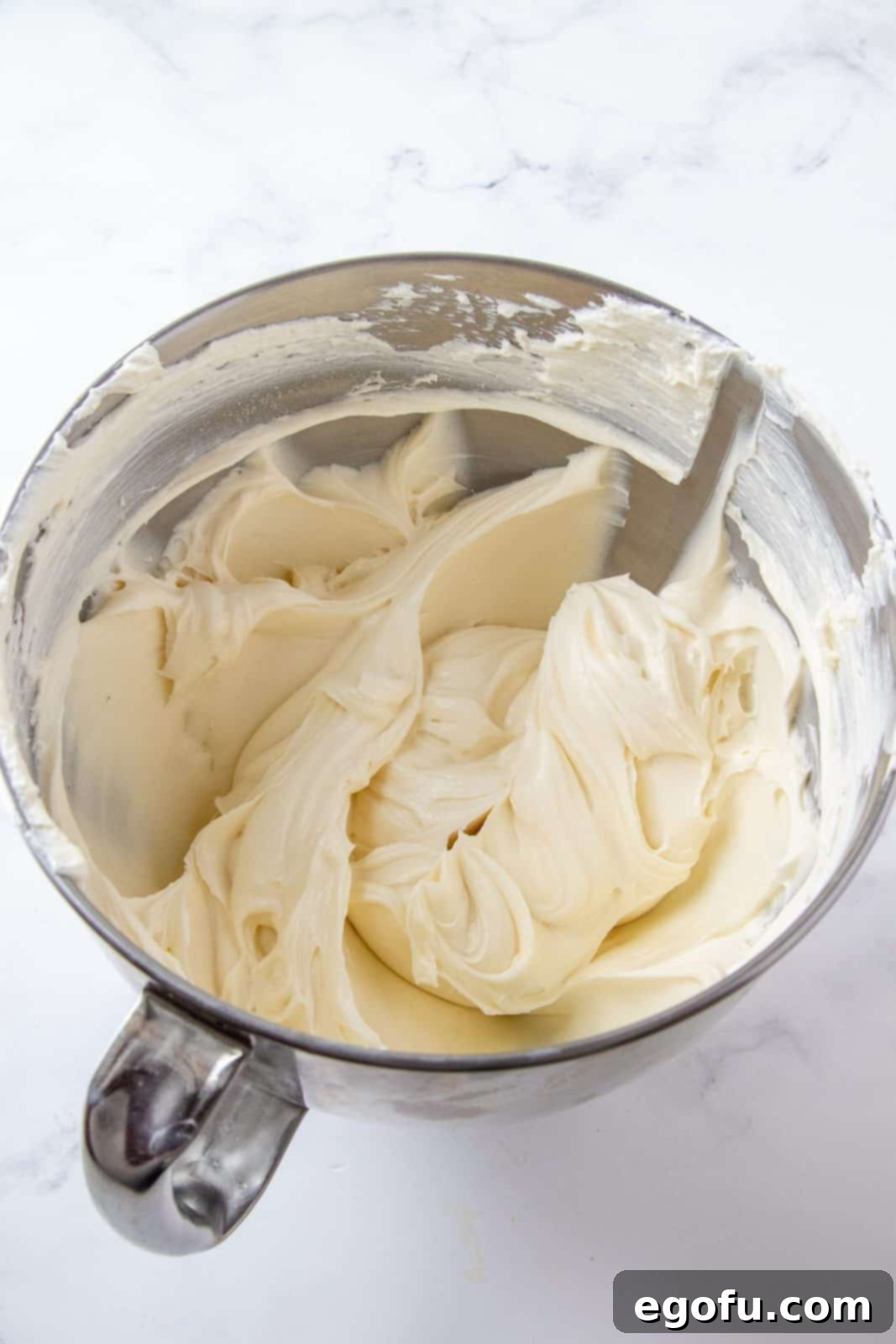 overhead photo of whipped cream cheese mixture in a silver mixing bowl