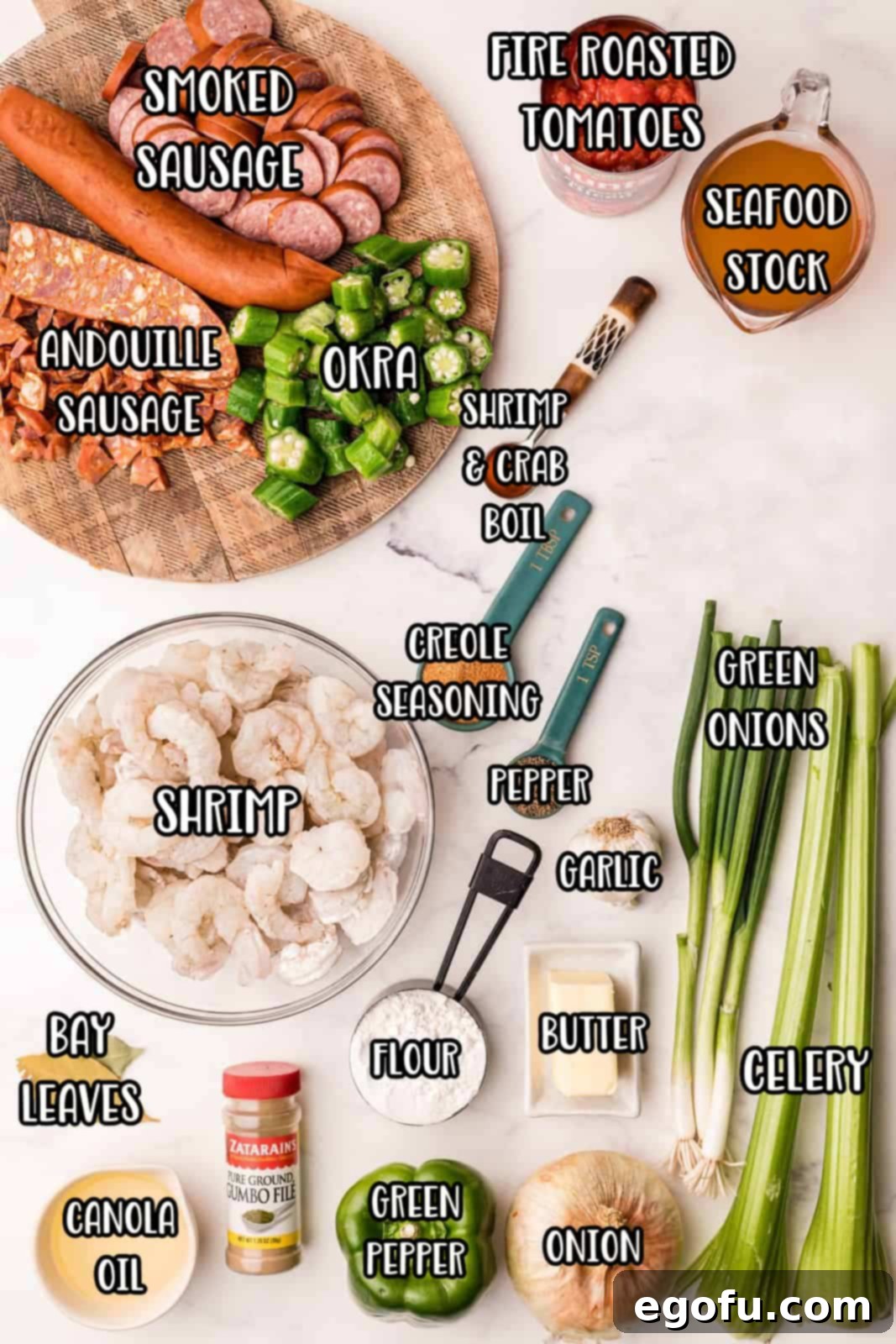 A vibrant display of fresh ingredients for Southern Shrimp Gumbo: butter, canola oil, all-purpose flour, sweet onion, green bell pepper, celery ribs, garlic, bay leaves, fire roasted tomatoes, seafood stock, black pepper, salt, creole seasoning, andouille sausage, smoked sausage, okra, shrimp and crab boil, shrimp, green onions, and gumbo filé.