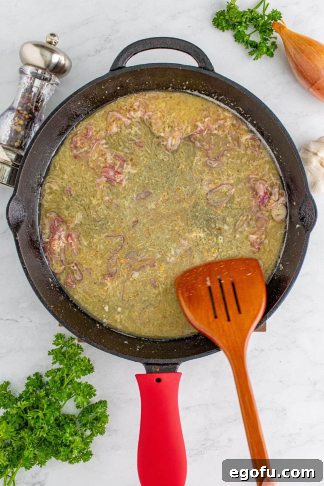 Hearty German Potato Salad 11 A spatula stirring the simmering dressing mixture in the skillet, slightly reducing and thickening.