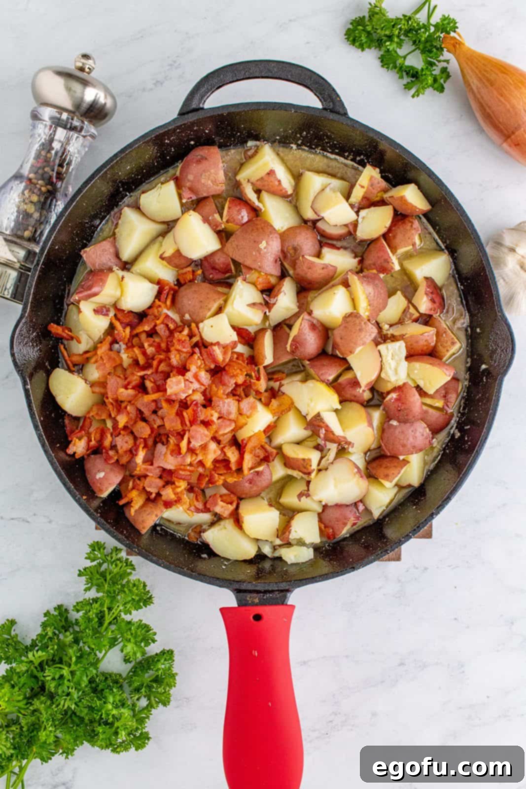 Hearty German Potato Salad 12 Diced potatoes and crispy bacon being added to the warm dressing in the skillet, ready to be tossed.