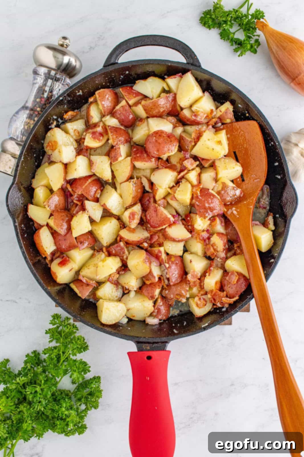 Hearty German Potato Salad 13 German Potato Salad being gently stirred in the cooking pan, ensuring all ingredients are coated with the warm dressing.