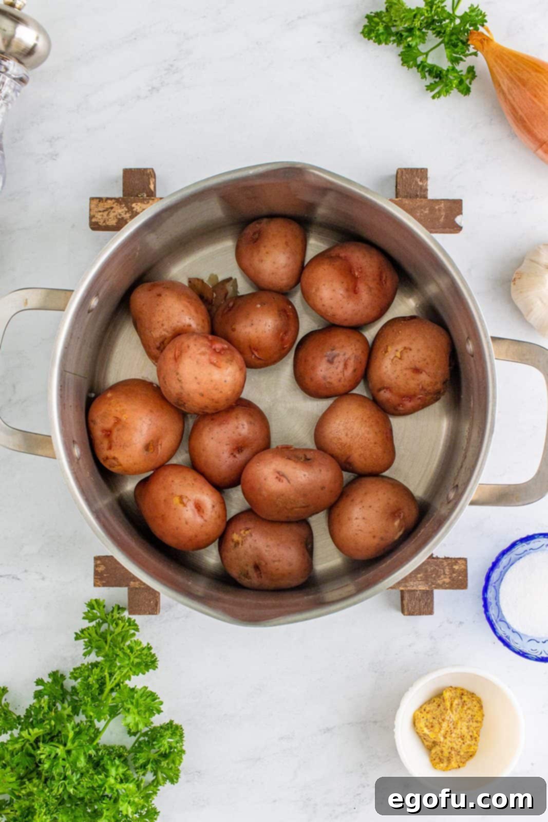 Hearty German Potato Salad 6 Potatoes after being drained, sitting in a pot with steam visibly rising to remove excess moisture.