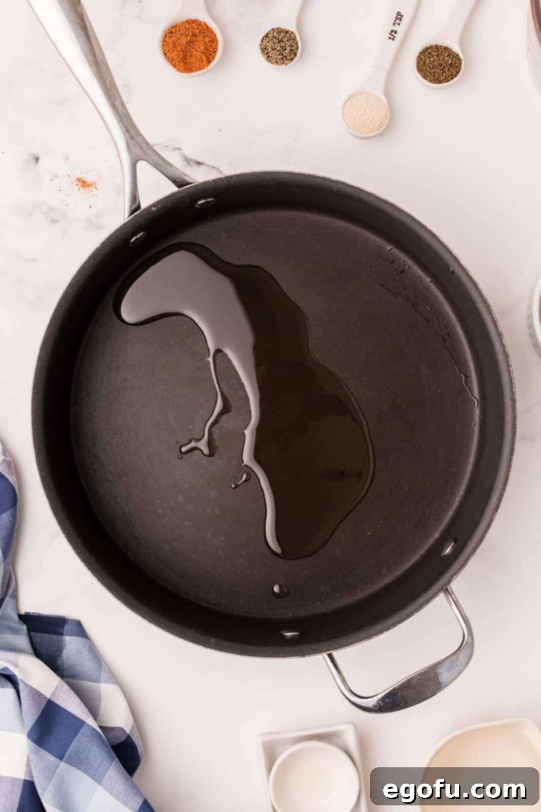 Canola oil glistening and hot in a large skillet over medium heat, perfectly ready for the addition of meats and vegetables.