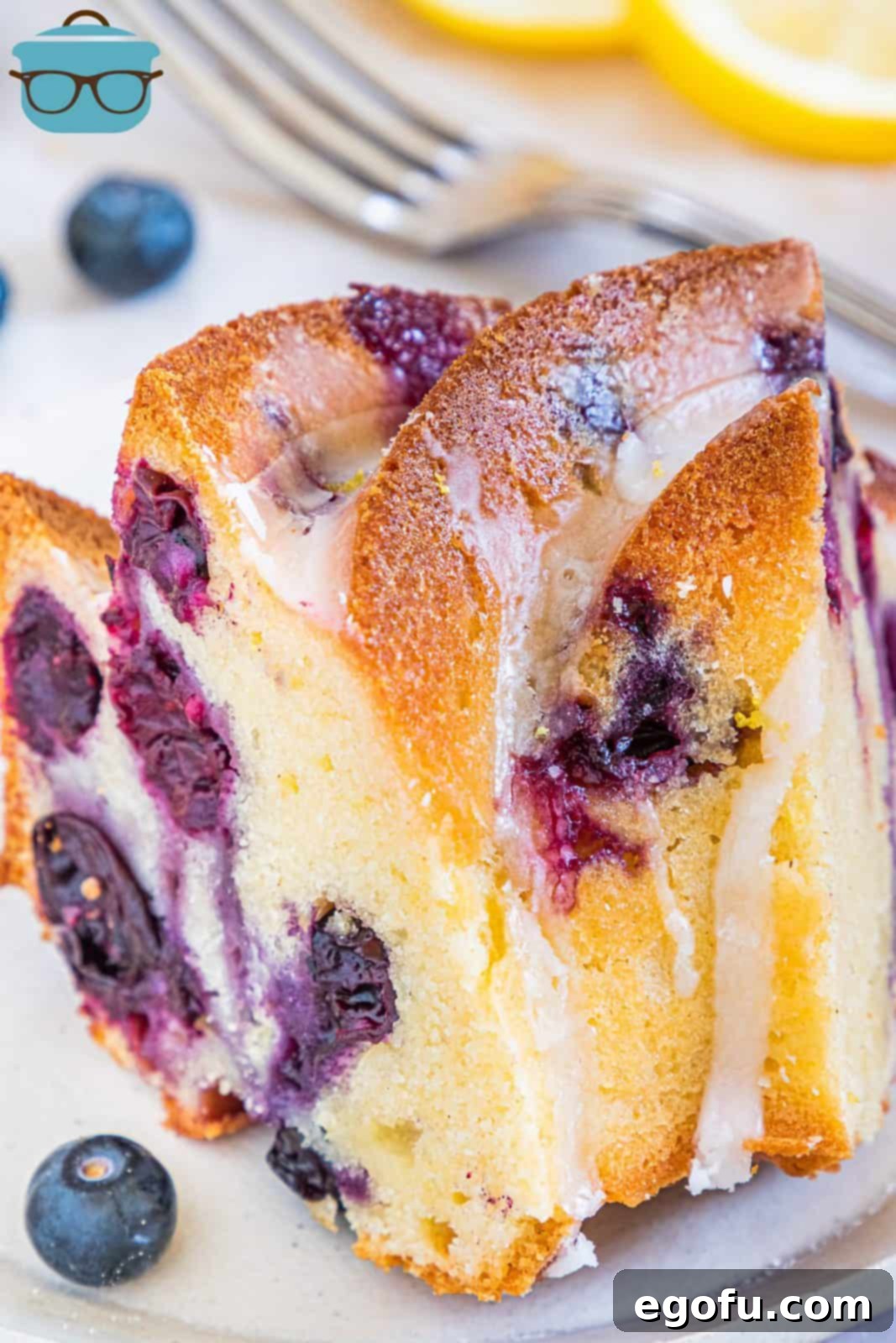 Overhead, close up photoof one slice of Lemon Blueberry Pound Cake with fork in background.