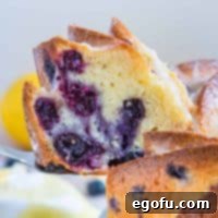 Square image of cake server holding up slice of Lemon Blueberry Pound Cake