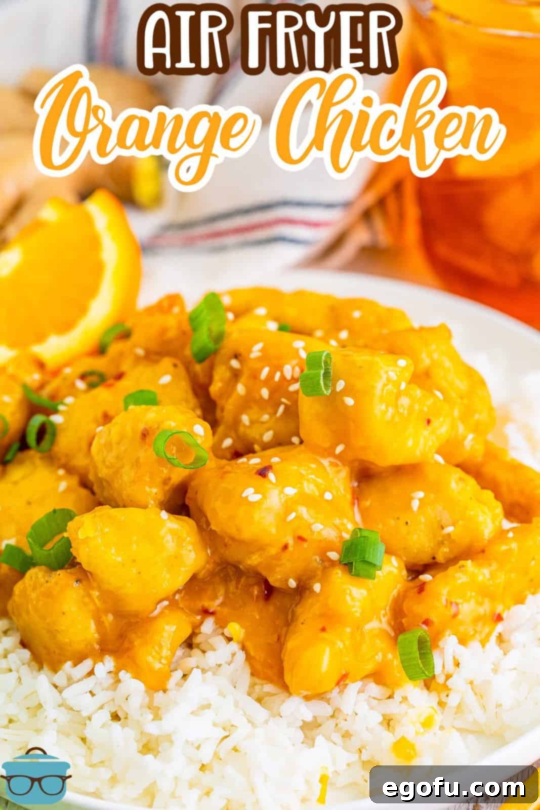 Golden Air Fryer Orange Chicken Delight 3 pieces of orange chicken shown in white rice with a slice of fresh orange on the side.