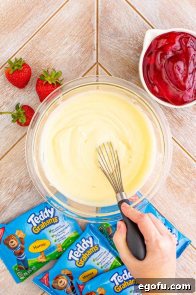 The Wandering Strawberry Cheesecake 6 Hand whisking together pudding and milk mixture