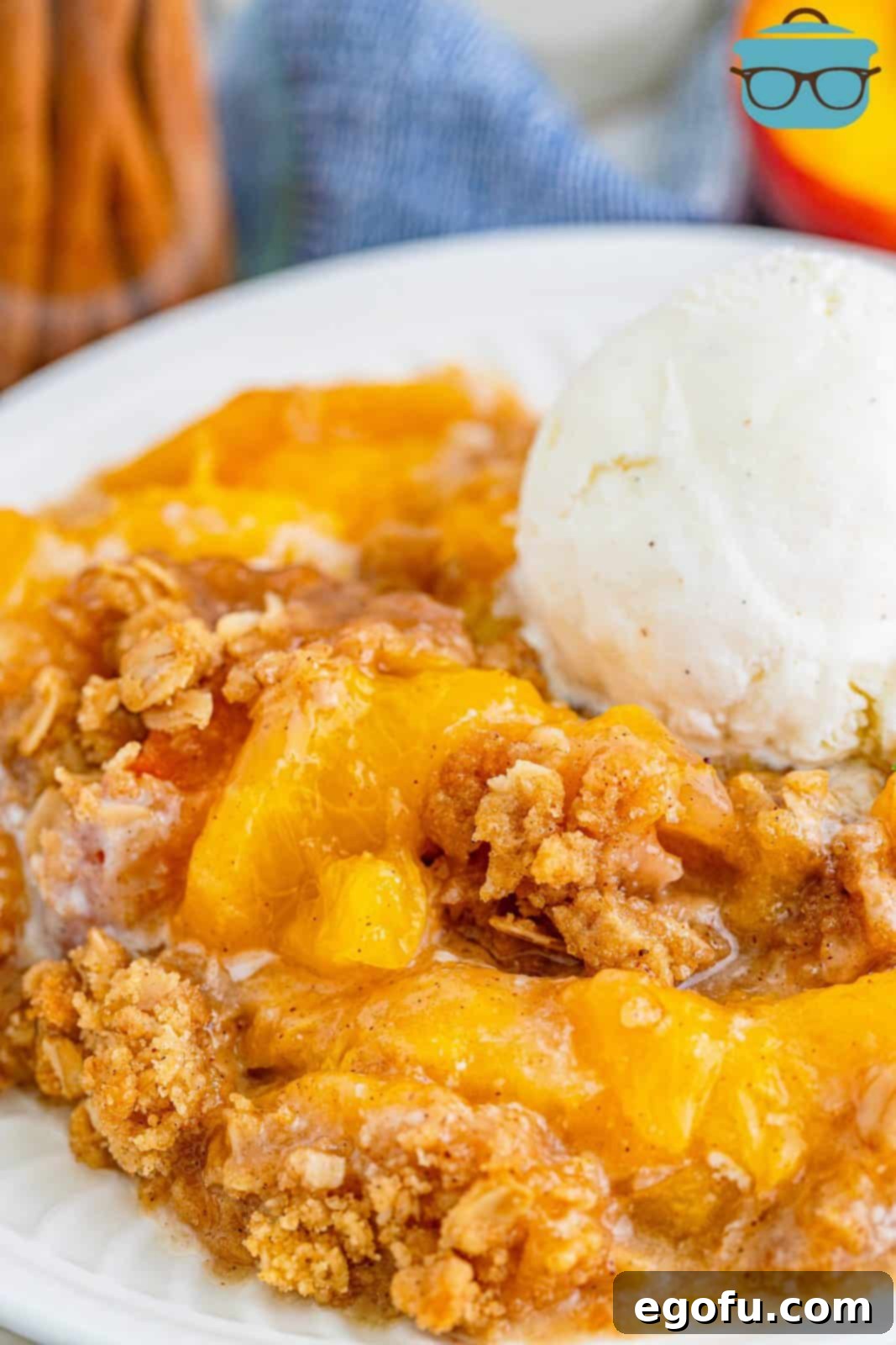 Golden Peach Crumble 10 Easy Fresh Peach Crisp on plate topped with ice cream.