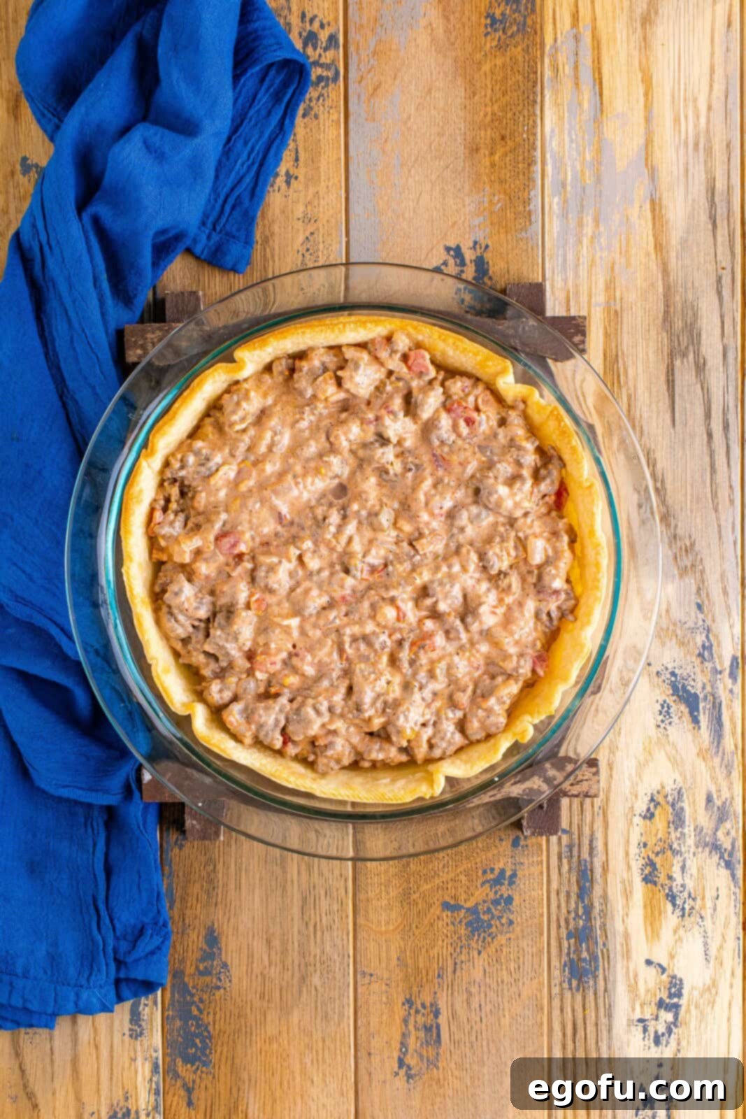 Effortless Taco Bake 11 taco mixture spread out into a pie crust.