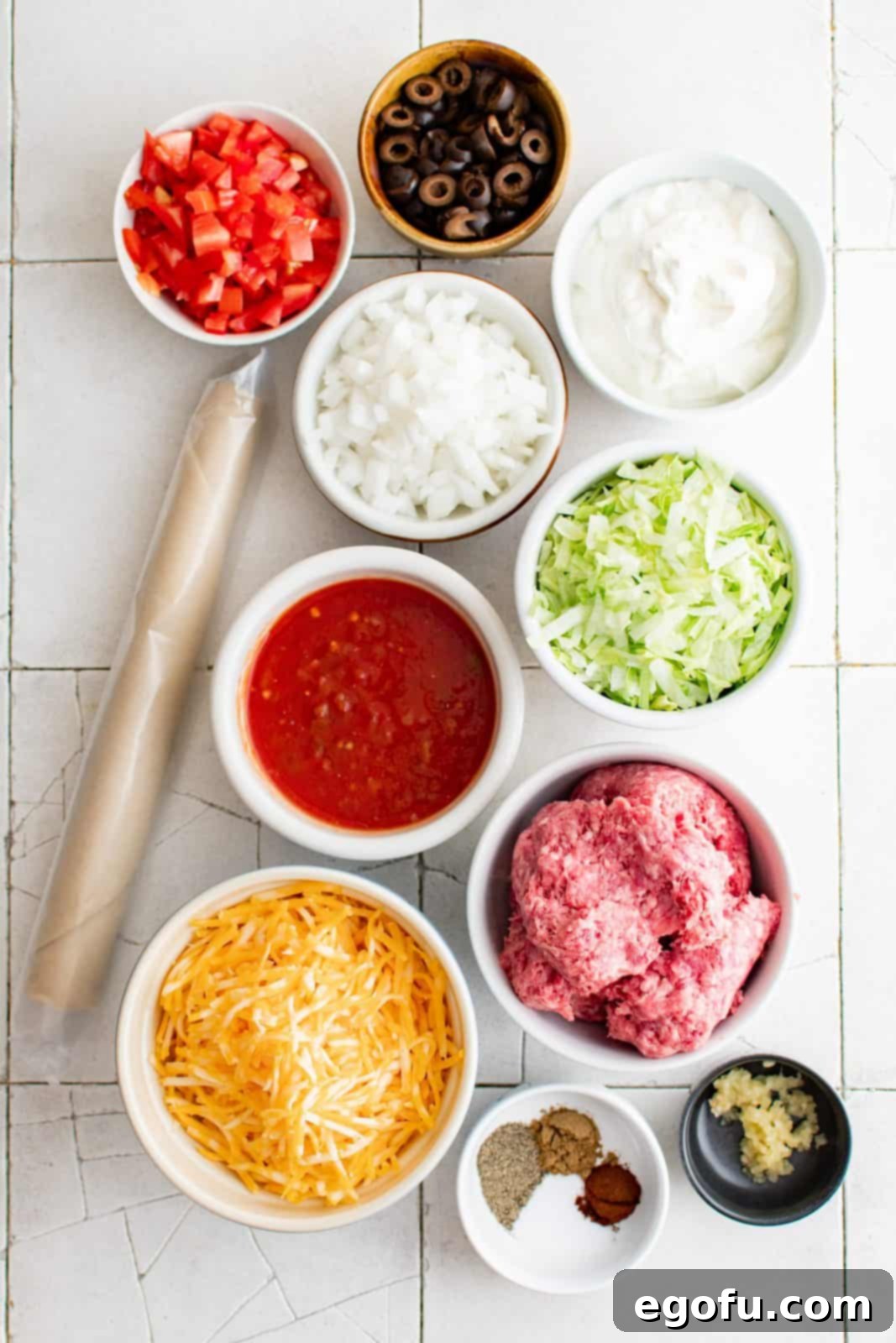 Effortless Taco Bake 3 Ingredients needed: premade pie crust, ground beef, white onion, garlic, salt, black pepper, cumin, chili powder, Colby Jack cheese, salsa, sour cream, shredded iceberg lettuce, tomatoes and black olives.