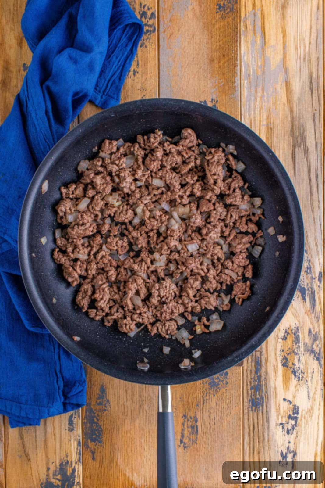 Effortless Taco Bake 6 cooked ground beef and onion in a skillet.