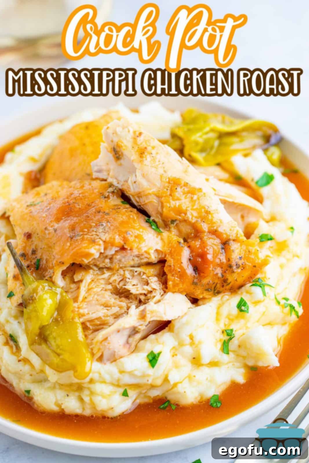 Crock Pot Mississippi Roast Chicken on platter with mashed potatoes, peppers and gravy.