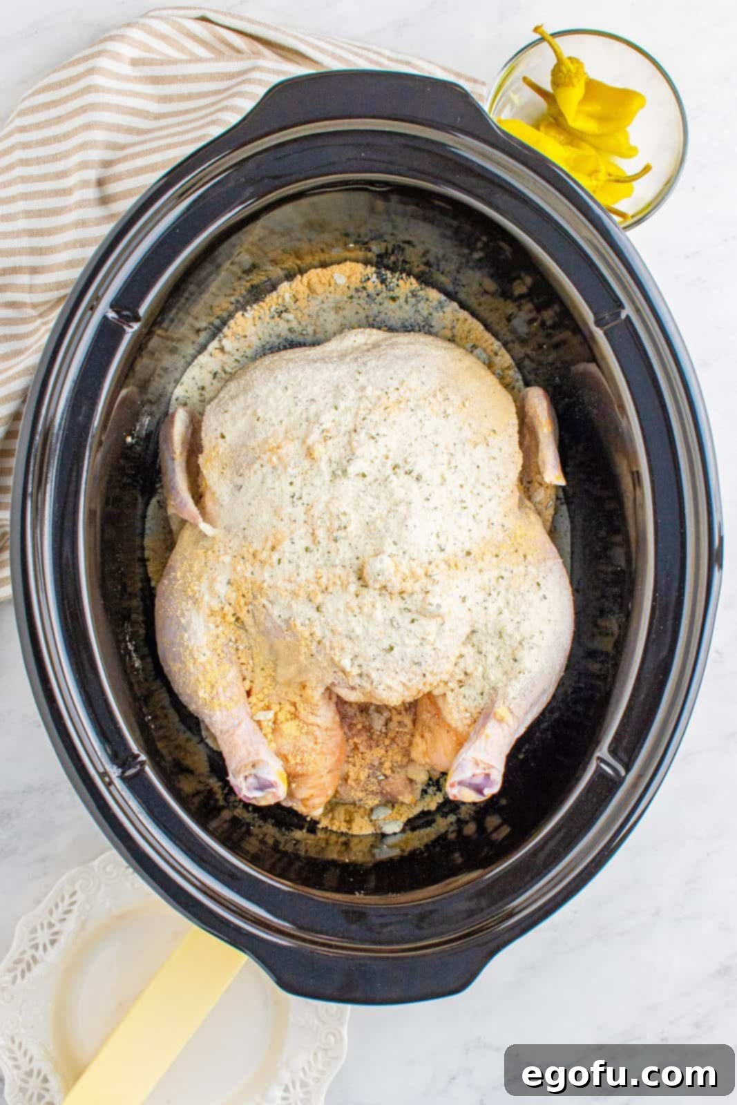 Chicken gravy and ranch mix sprinkled over chicken in crock pot.