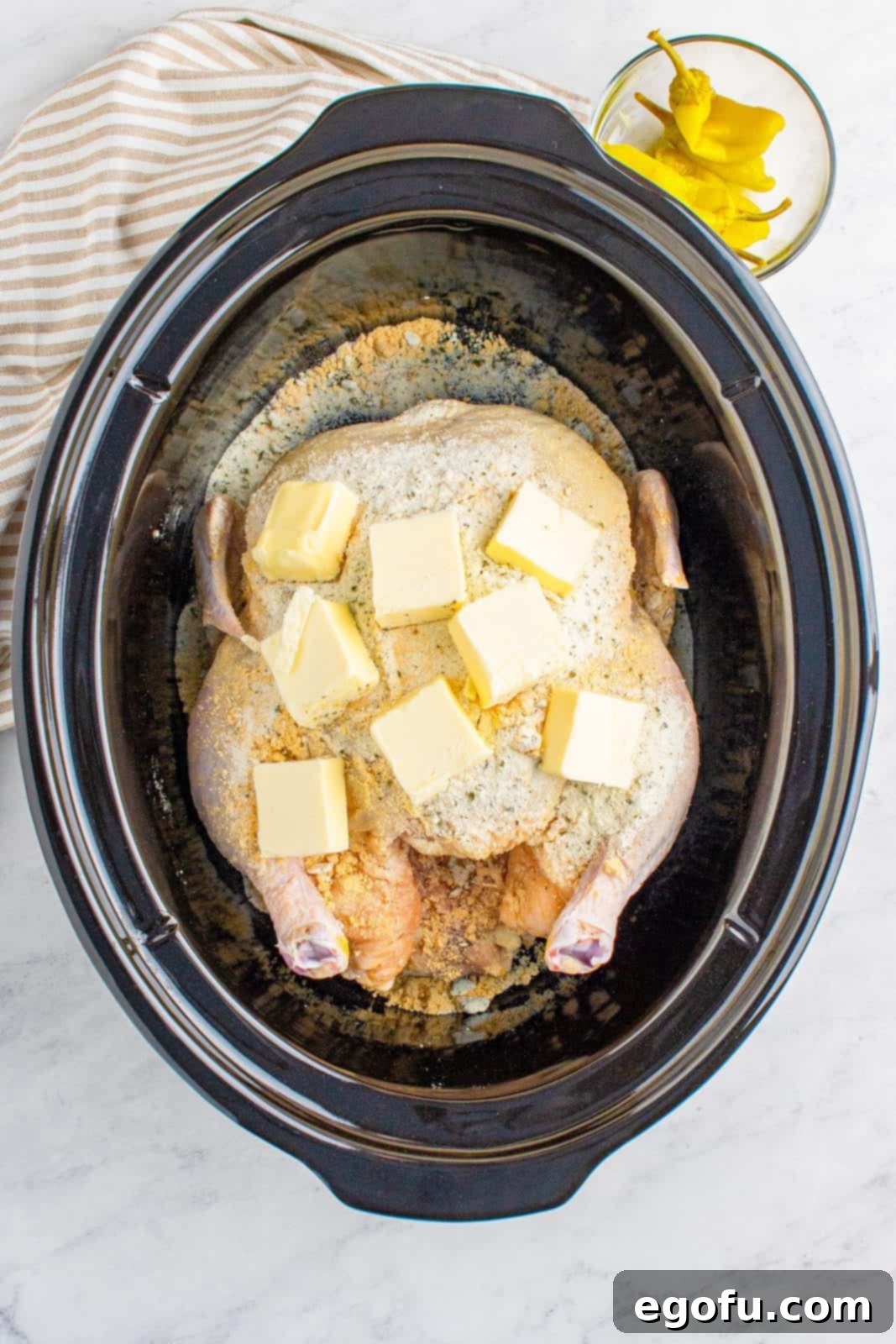 Pats of butter on top of chicken in crock pot.