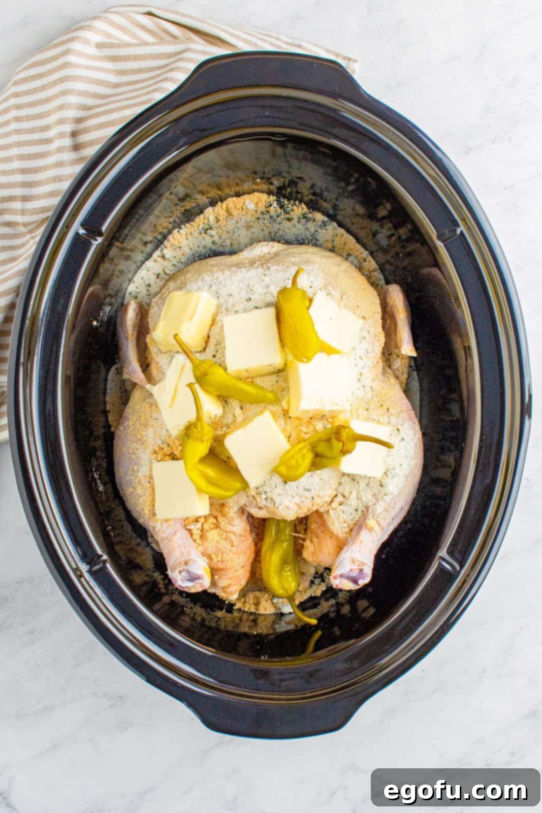 Pepperoncini peppers added to the crock pot with chicken.