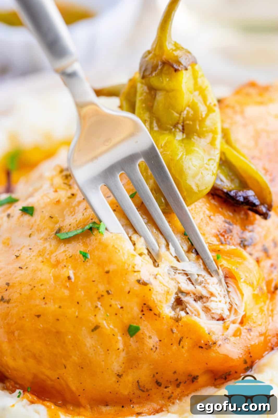 Fork going into piece of Crock Pot Mississippi Roast Chicken on plate.