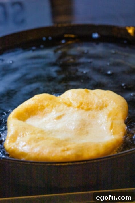 Piece of dough being fried in oil.