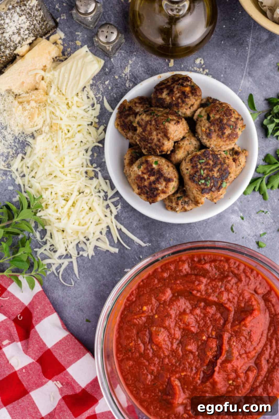 Easy Cheesy Skillet Meatballs 4 Array of ingredients for Meatball Parmesan Skillet: marinara sauce, meatballs, mozzarella, parmesan, salt, pepper, and fresh herbs.