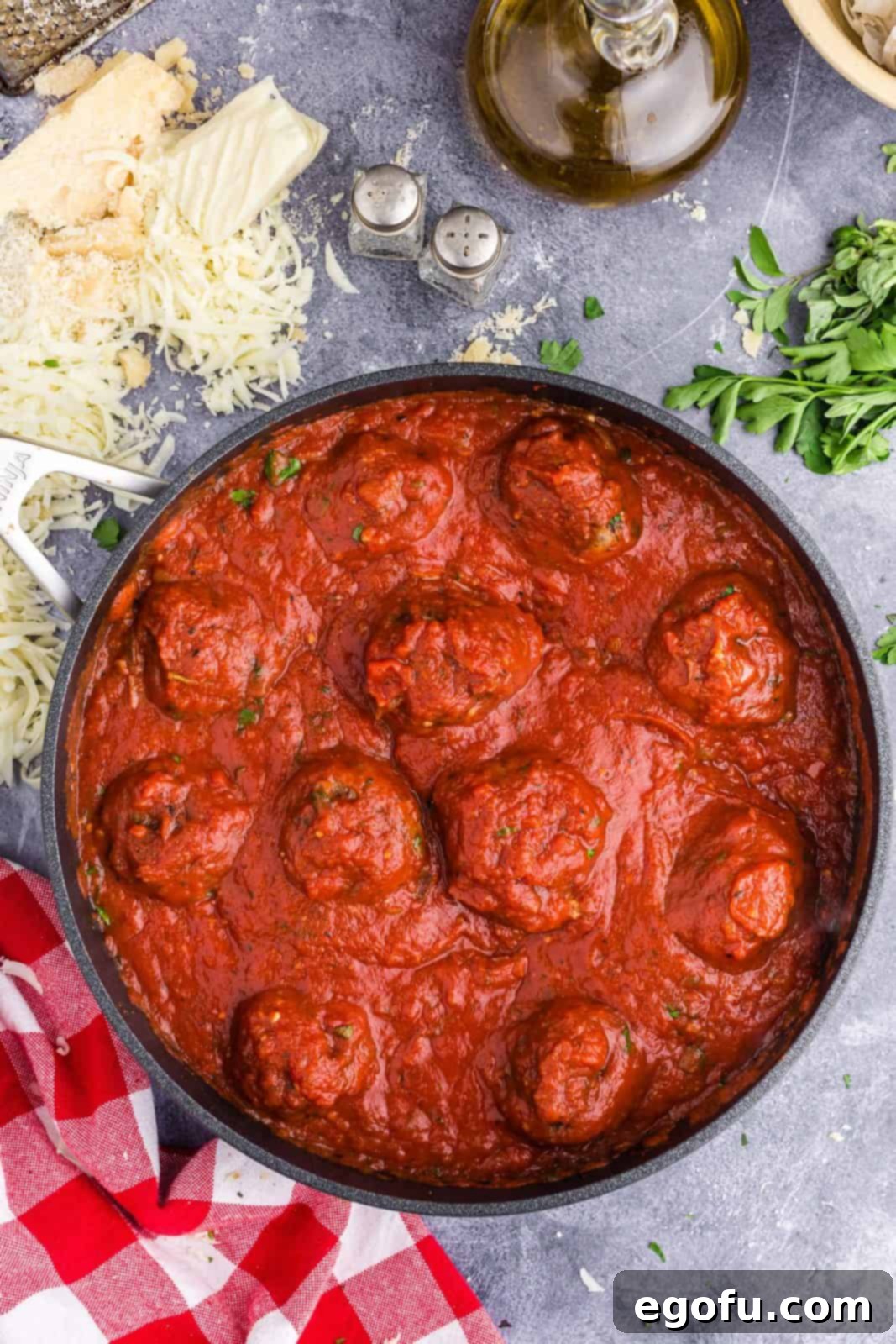 Easy Cheesy Skillet Meatballs 5 Meatballs simmering in rich marinara sauce in an oven-safe skillet.
