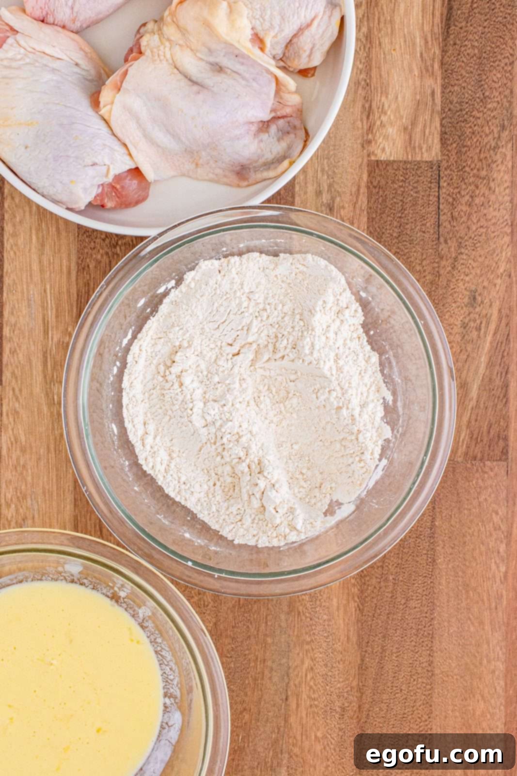 Dry ingredients whisked together in glass nowl. A close-up of the seasoned flour mixture.