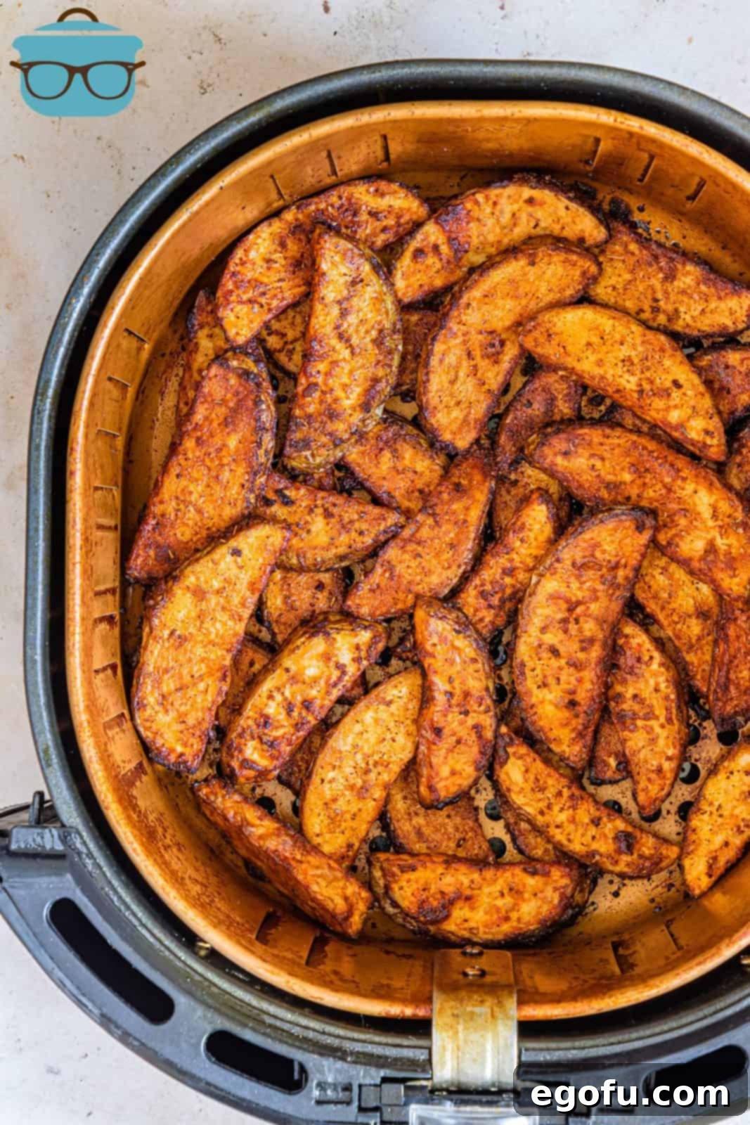 Finished Air Fryer Potato Wedges in air fryer basket.