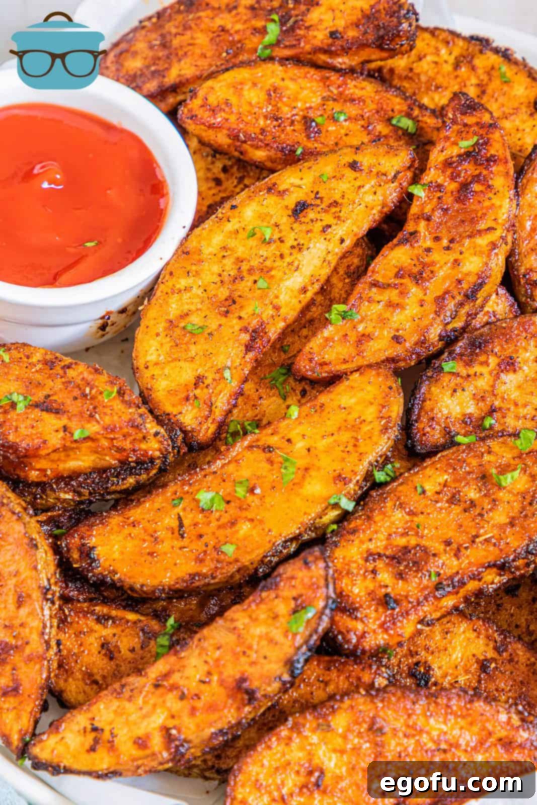 Plated Potato Wedges garnished with parsley with ketchup on side.