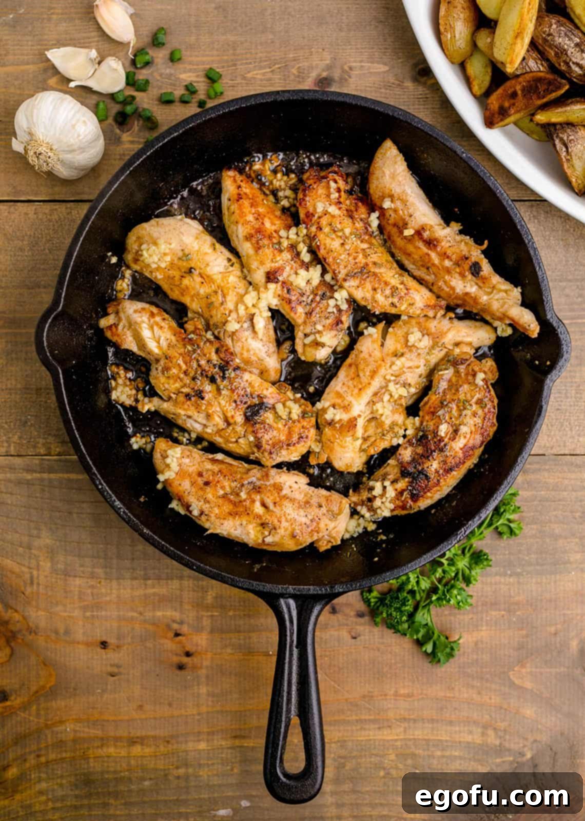 Golden Garlic Butter Chicken and Crispy Potatoes 12 Golden-brown chicken pieces cooking in the skillet, infused with aromatic garlic and remaining marinade.