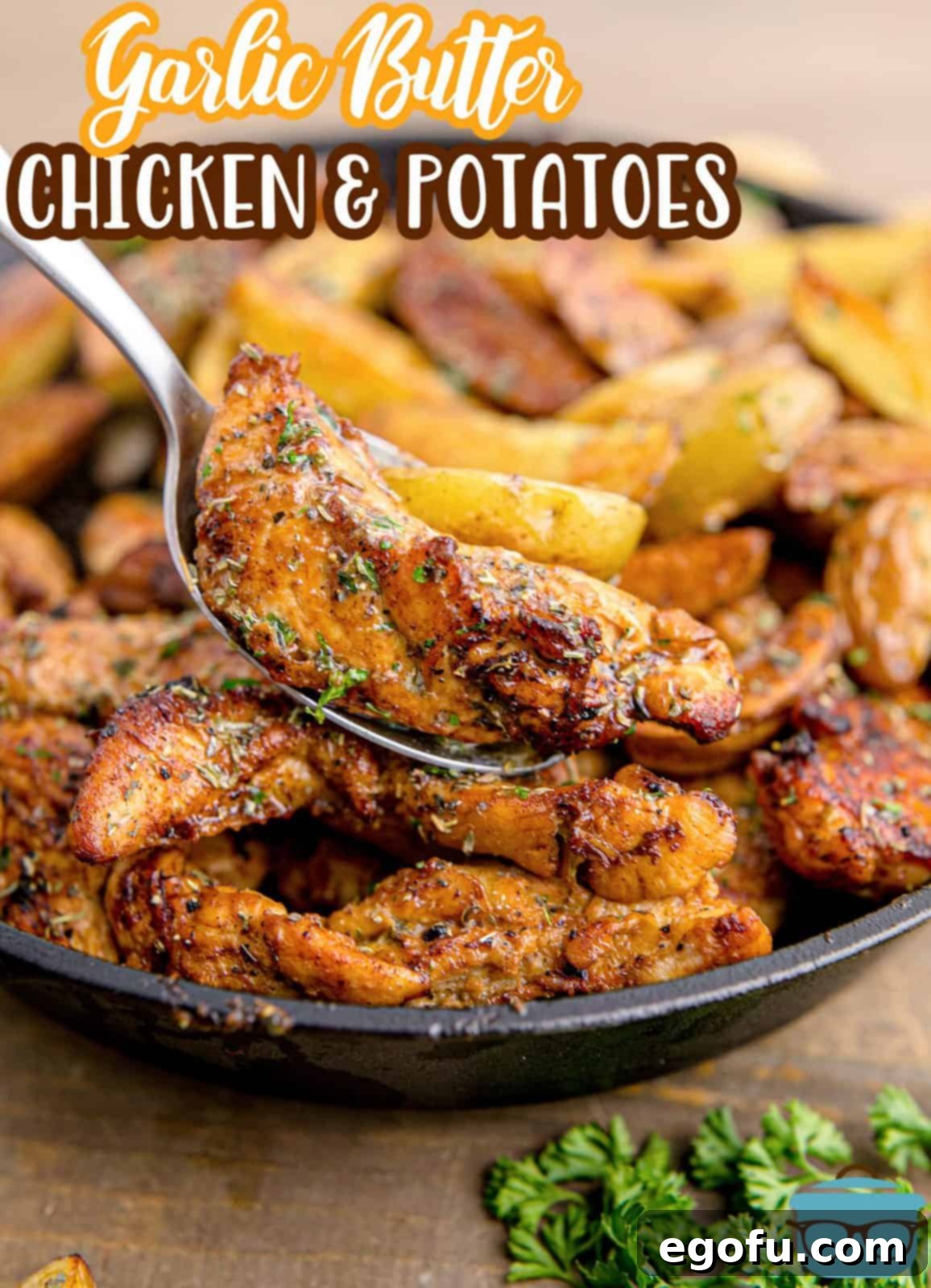 Golden Garlic Butter Chicken and Crispy Potatoes 3 Close-up of a spoon lifting a piece of Garlic Butter Chicken and Potatoes, showcasing the golden-brown chicken and tender potato chunks.