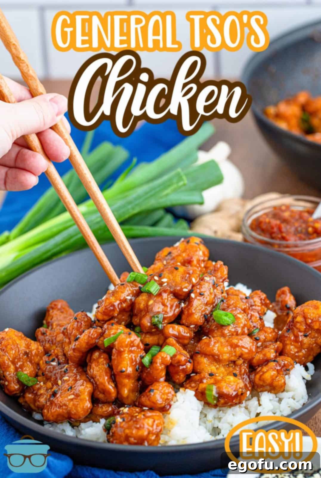 Delicious homemade General Tso's Chicken served over fluffy white rice with chopsticks, garnished with fresh scallions and toasted sesame seeds, ready to be enjoyed.