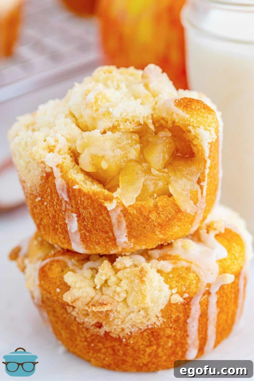 Quick Apple Pie Bites 2 Two Easy Apple Pie Cups stacked on top of one another with a bite taken out of the top cup, displaying the apple filling and crumble.