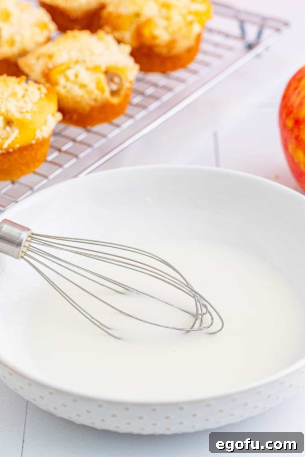 Quick Apple Pie Bites 13 Glaze mixture being whisked together in a bowl, showcasing its smooth texture.