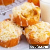 Quick Apple Pie Bites 17 Square image of Apple Pie Cups stacked and glazed with a bite taken out of the top cup.