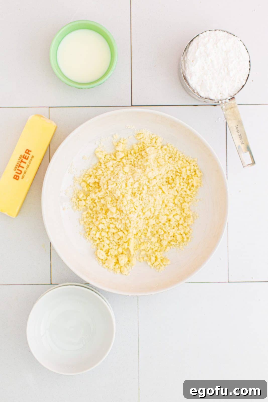 Quick Apple Pie Bites 8 Crumble topping mixture in a bowl, showing the texture resembling wet sand with small pieces of butter after being cut in.