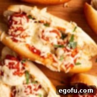 Square image of finished subs overhead with melted cheese and parsley.