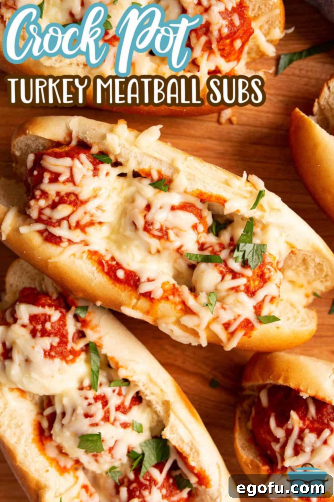 Pinterest image overhead of finished Crock Pot Turkey Meatball Subs with melted cheese and parsley.