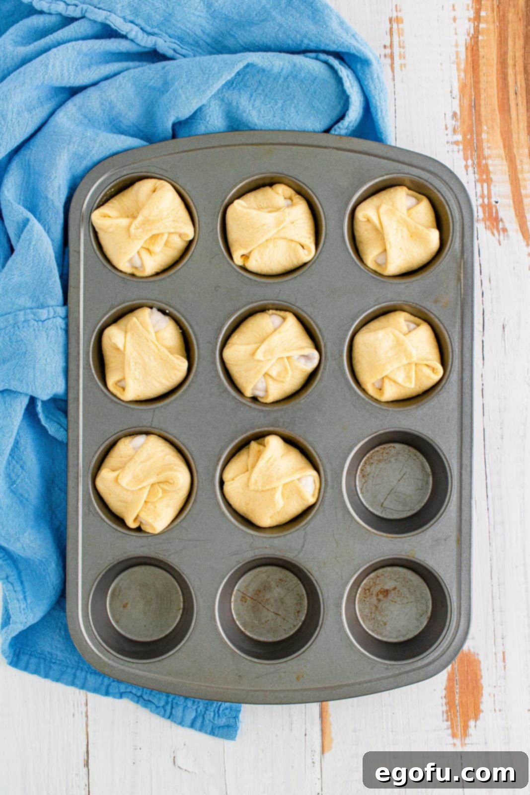 Crescent Squares folded over gravy to seal in muffin pan.