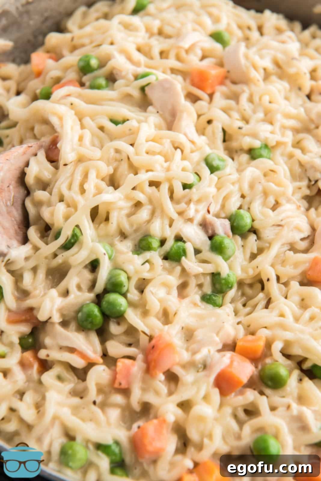Close up of finished Chicken Pot Pie Ramen in pan, showcasing the creamy texture and colorful vegetables.