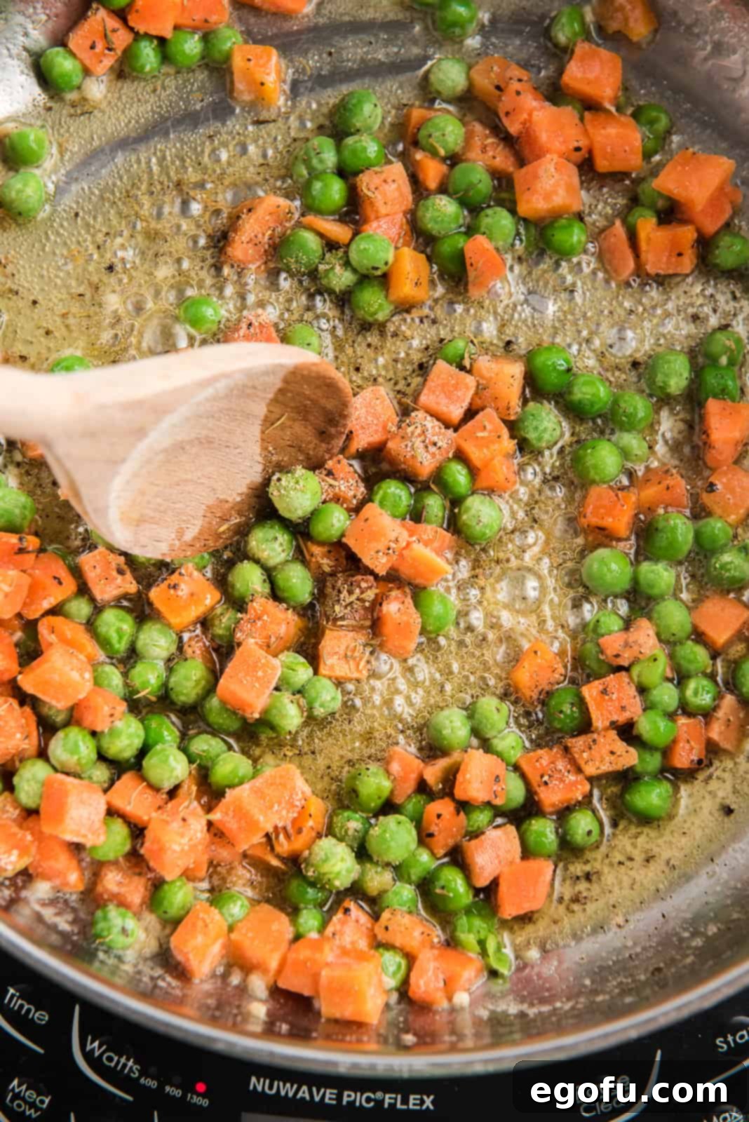 Frozen mixed vegetables and various herbs and spices added to the melted butter and garlic in a skillet.