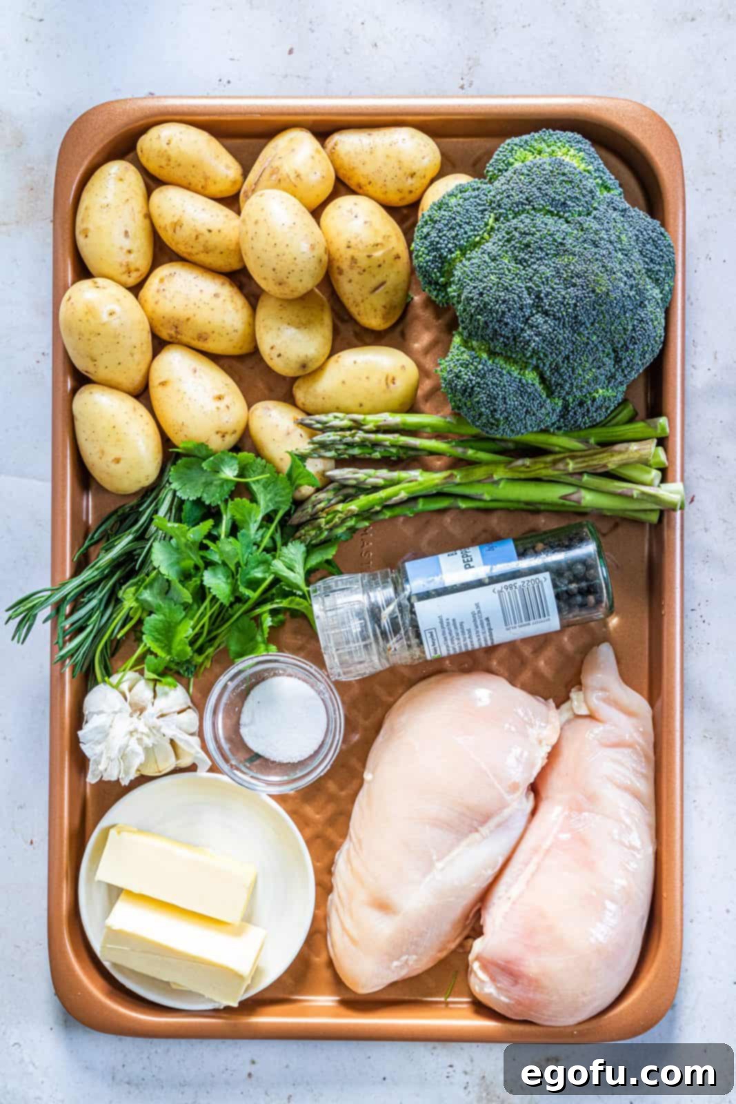 Garlic Butter Sheet Pan Chicken Dinner 5 Ingredients needed: salted butter, garlic, parsley, salt, pepper, chicken breasts, baby potatoes, broccoli, asparagus and rosemary sprigs.