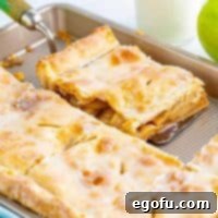 A square image of a piece of glazed Apple Slab Pie on a serving plate.