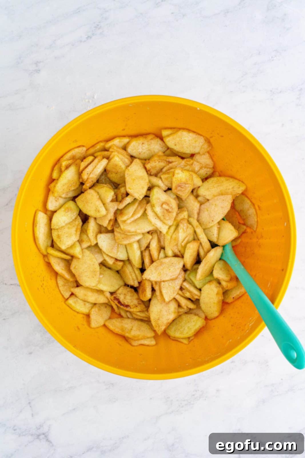 The apple mixture fully stirred and combined in the bowl, ready to be spread.