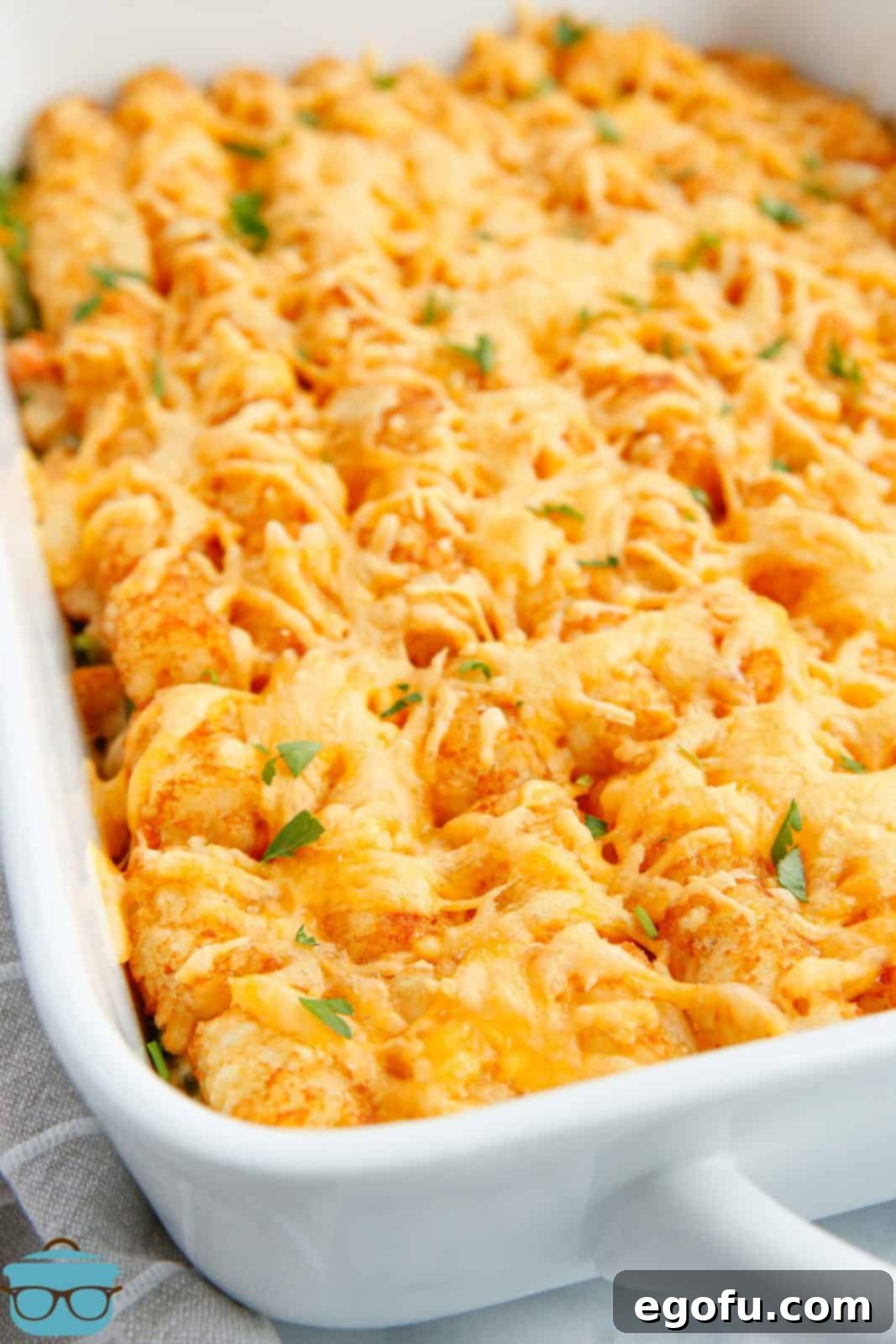 Finished Tater Tot Chicken Pot Pie in pan with melted cheese and parsley.