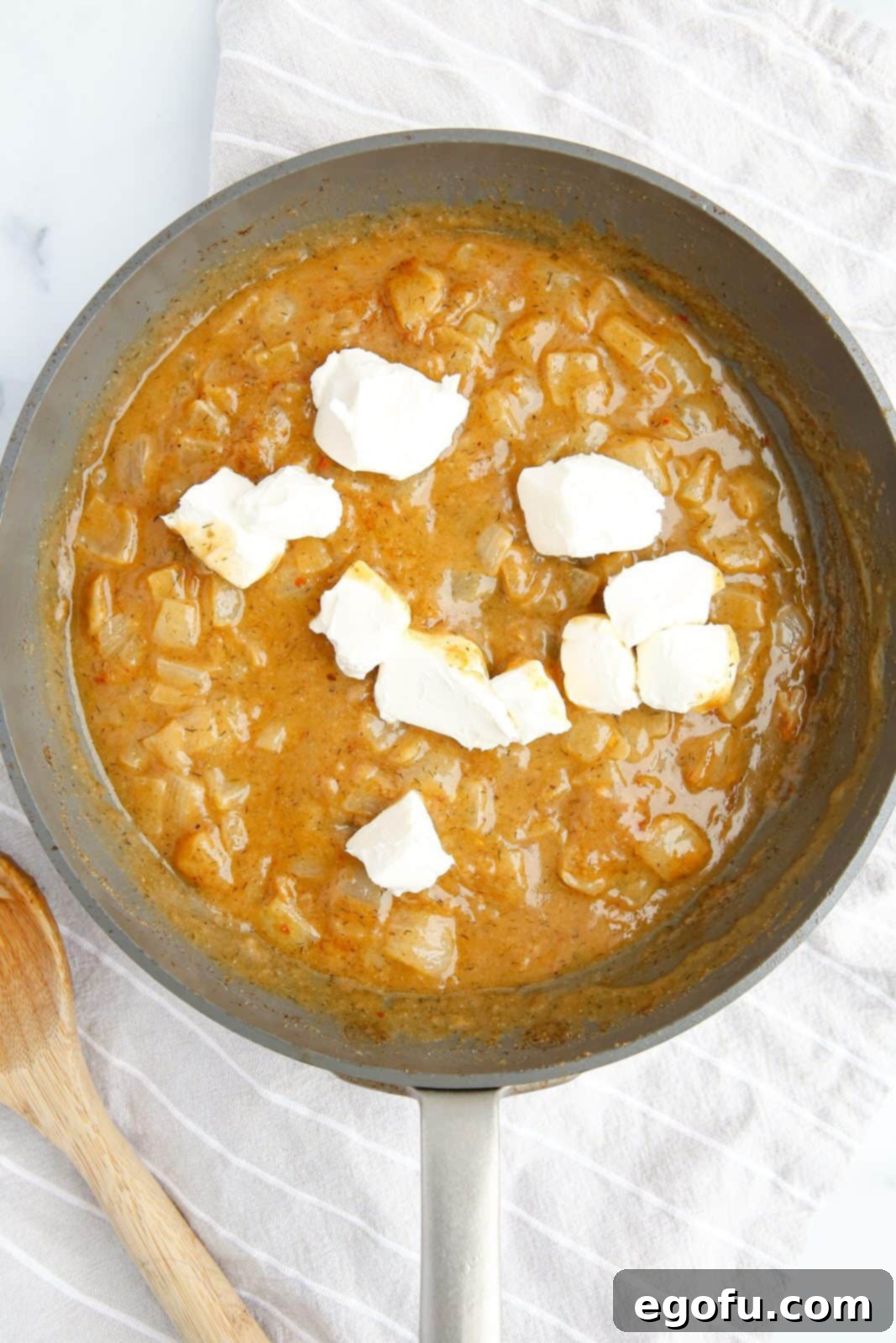 Melted butter, flour, onion, spices and broth mixture with cream cheese chunks and milk added.