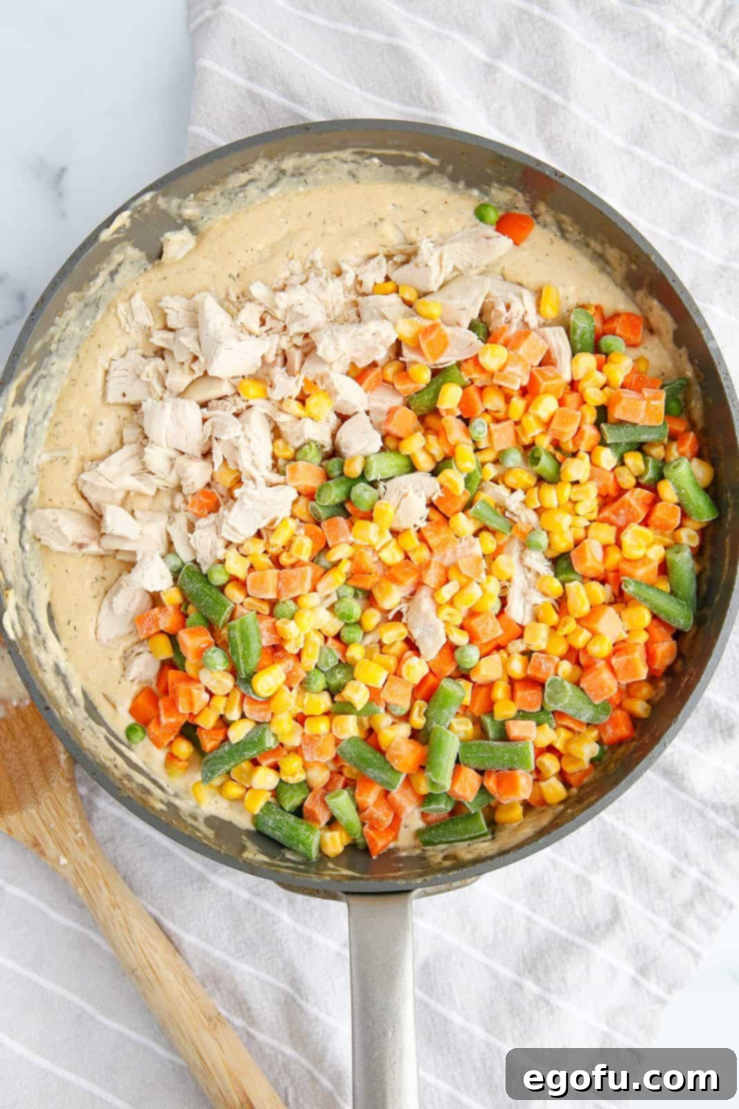 Frozen vegetables and chicken added to sauce miture.