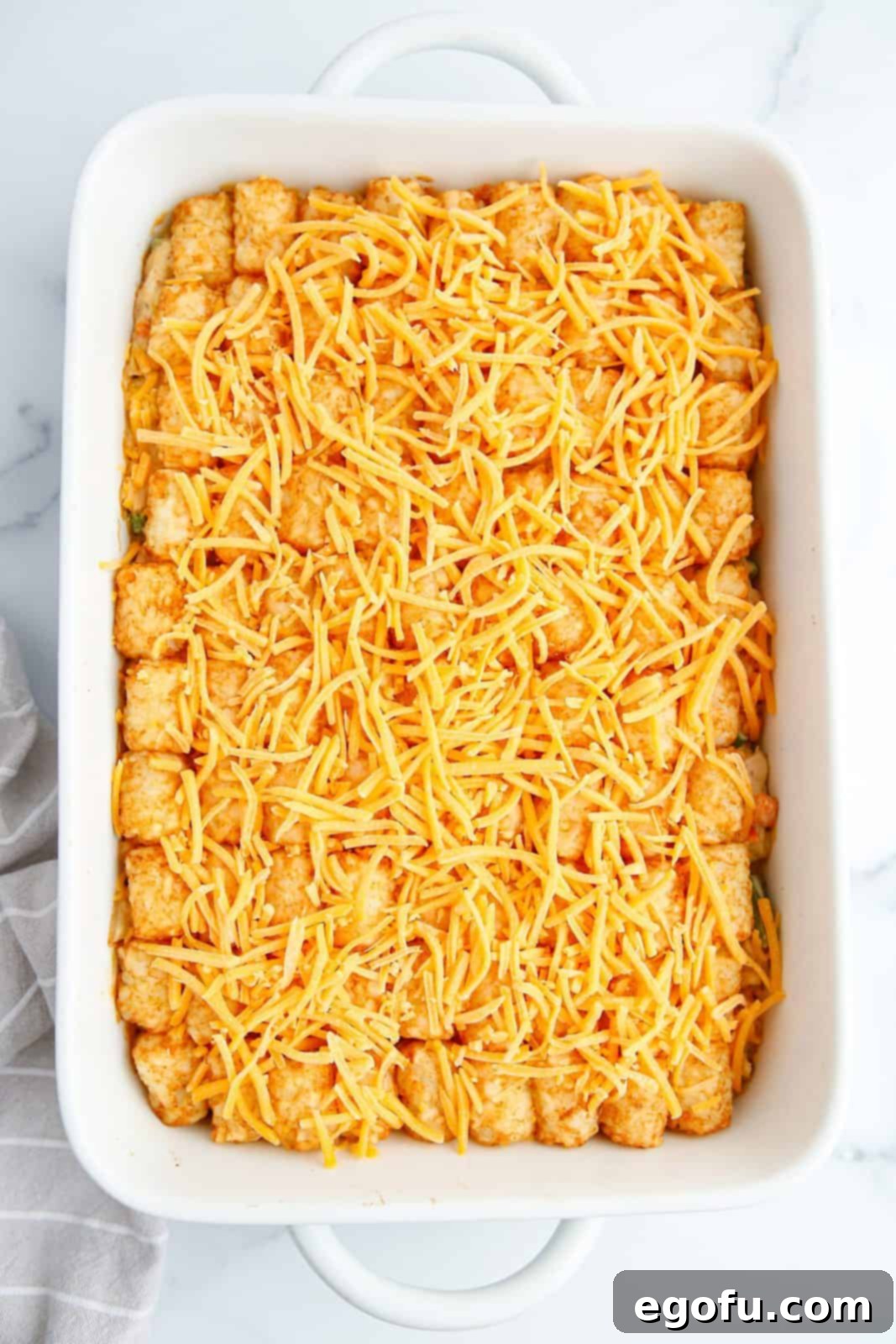 Cheese sprinkled over tater tots.