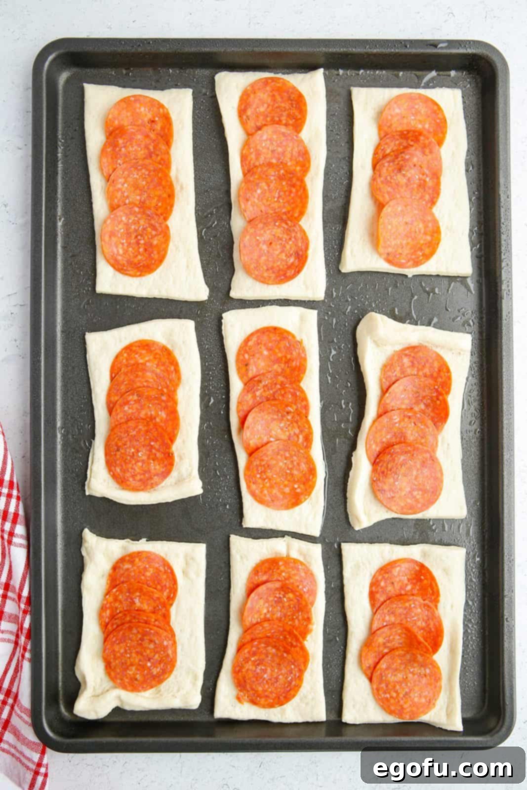 Stuffed Pizza Breadsticks 6 Pepperoni placed on top of cut up rectabgles of pizza dough.