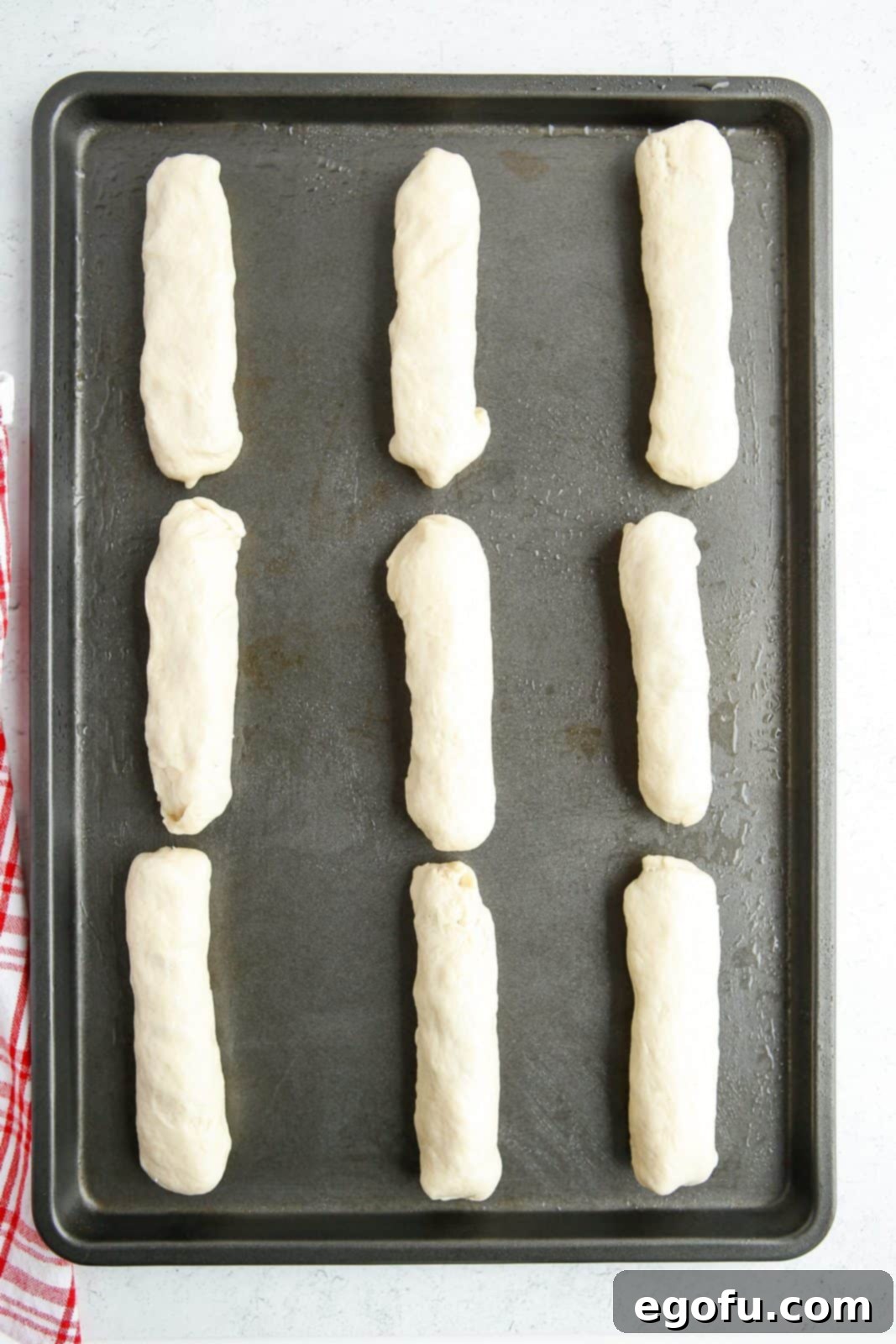 Stuffed Pizza Breadsticks 8 Rolled up and sealed breadsticks on baking sheet.