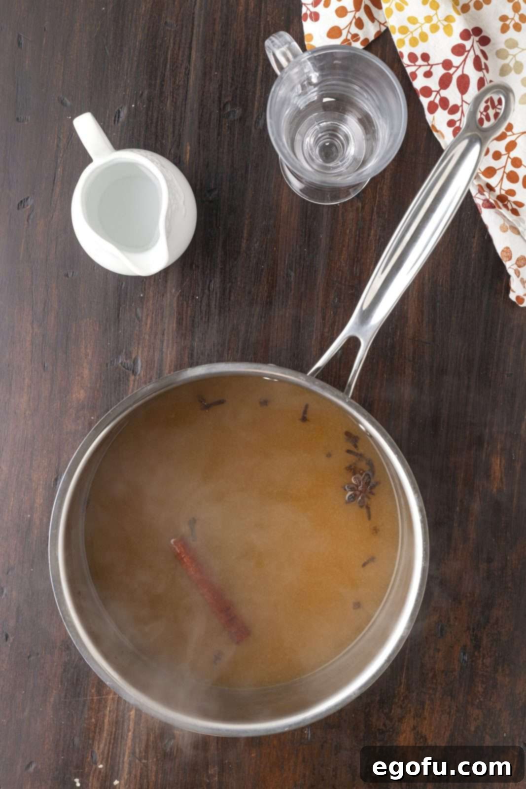 The cocktail ingredients simmering gently in a saucepan on the stove, releasing their aromatic spices.