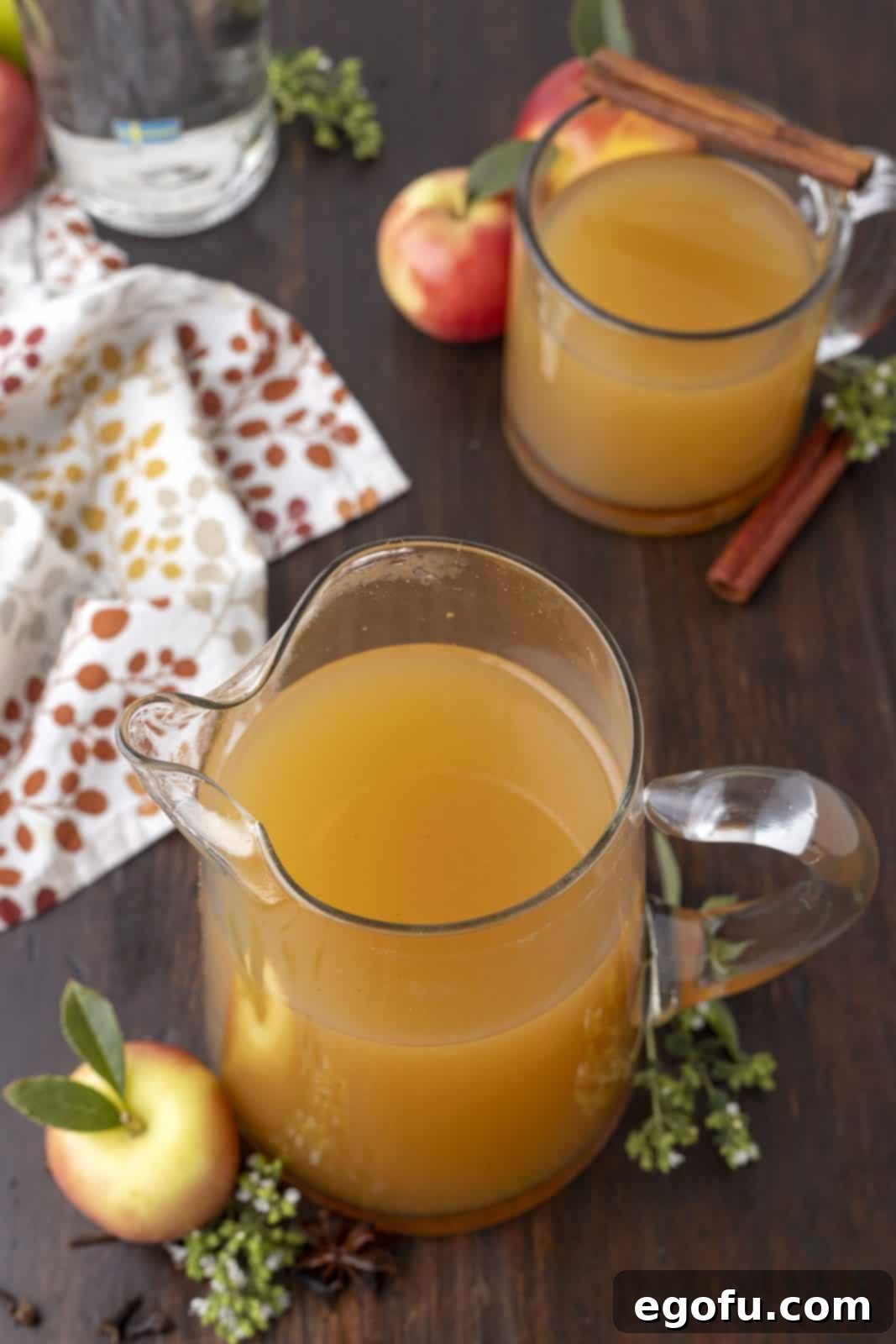 The finished Warm Apple Cider Cocktail presented in a clear glass pitcher, ready to be served.