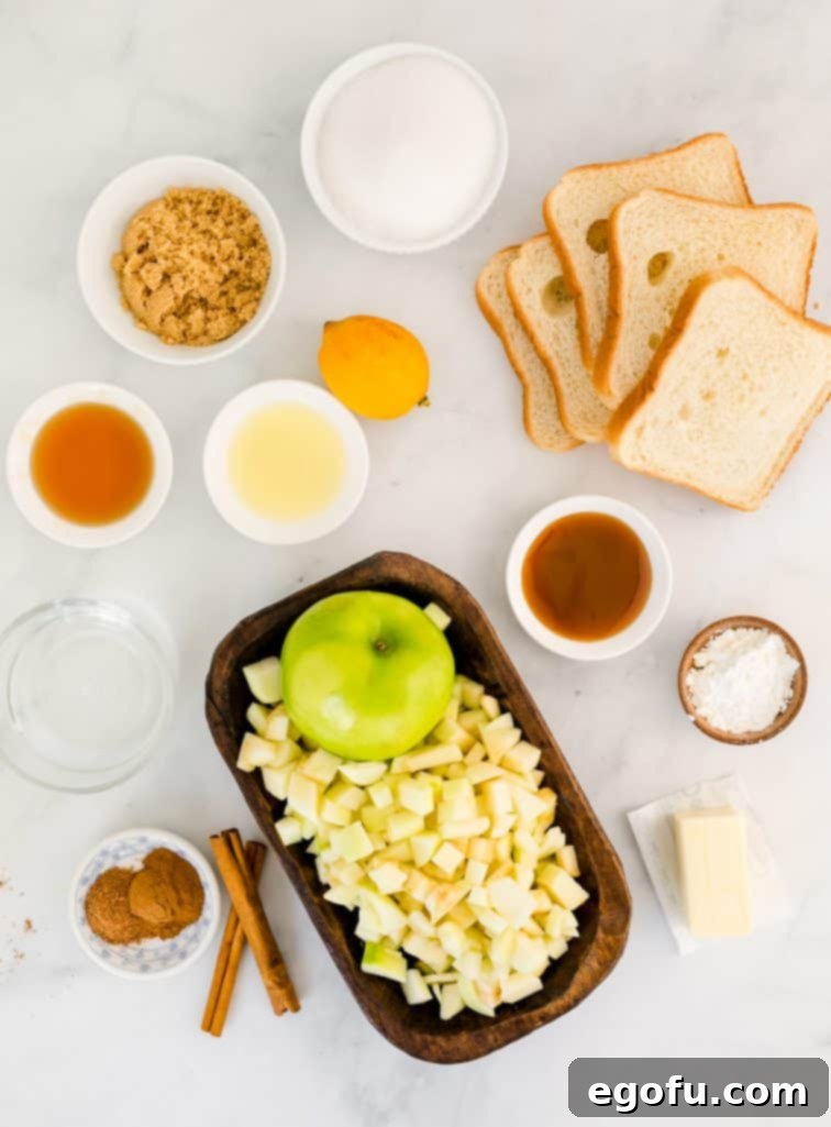 A vibrant flat lay of all the essential ingredients laid out: water, brown sugar, maple syrup, caramel syrup, fresh lemon juice, cornstarch, crisp apples, sandwich bread, granulated sugar, aromatic cinnamon, fragrant nutmeg, and melted butter, ready for baking.